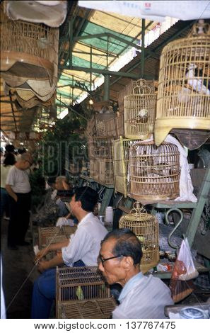 GUANGZHOU / CHINA - CIRCA 1987: Vendors sell pet birds in cages in Guangzhou's Qingping Market.