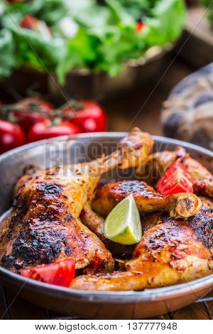 Grilled chicken legs lettuce and cherry tomatoes limet olives. Traditional cuisine. Mediterranean cuisine.