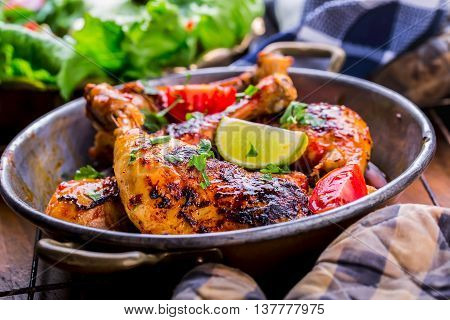 Grilled chicken legs lettuce and cherry tomatoes limet olives. Traditional cuisine. Mediterranean cuisine.