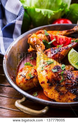 Grilled chicken legs lettuce and cherry tomatoes limet olives. Traditional cuisine. Mediterranean cuisine.