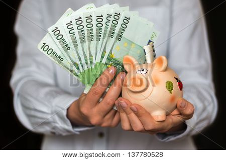 Young Woman With Piggy Bank And Euro Money Banknotes