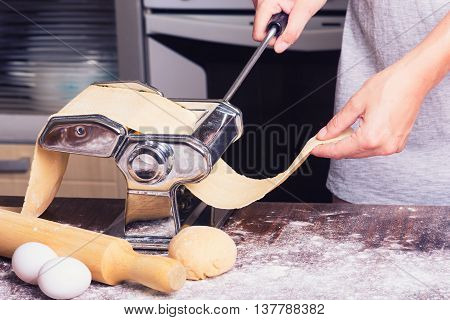 fresh pasta and pasta machine on kitchen table