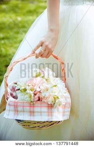 Wedding gentle bouquet in a basket holding bride hand.