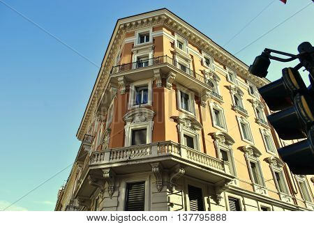 corner of a historic building with balconies on a background of clear sky