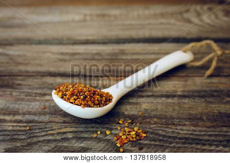 Bee pollen on old wooden background. Toned image.