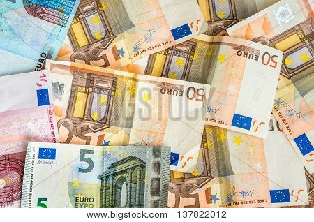 Euro banknotes scattered over the wooden table