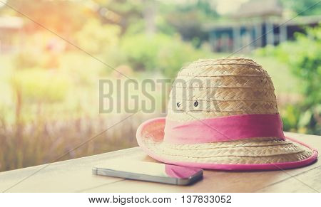 Farmer Hat with smart phone for Modern hi technology farmer on table vintage tone.