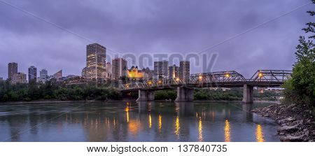 EDMONTON, CANADA - MAY 20: Panorama of Edmonton's skyline at dusk on May 20, 2016 in Edmonton, Alberta. The Saskatchewan River is in the foreground and a traffic bridge is on the right.