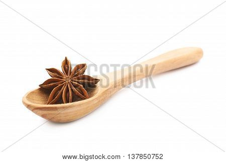 Chinese star anise seed served in a wooden spoon, composition isolated over the white background