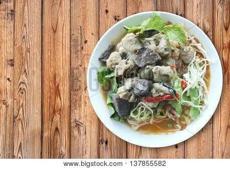 Curry chicken noodles (KHANOM CHIN) with vegetableThis is local Thai foods in Vermicelli rice on wooden background.