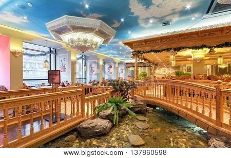 MOSCOW/RUSSIA - DECEMBER 2014. The interior of the deluxe restaurant of Uzbek cuisine - Babay Club in an oriental style. Pond and wooden bridge in the restaurant