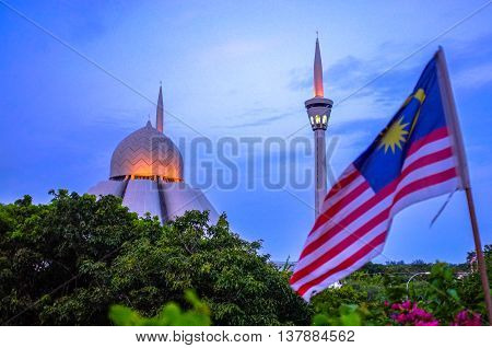 Labuan,Malaysia-Oct 2,2012:A view of An Nur Jamek Labuan mosque during Maghrib sunset with Malaysian flag at Labuan Malaysia.Its attract tourists from every corner of the world to visit this mosque.