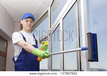 Professional cleaning. Young man washes window