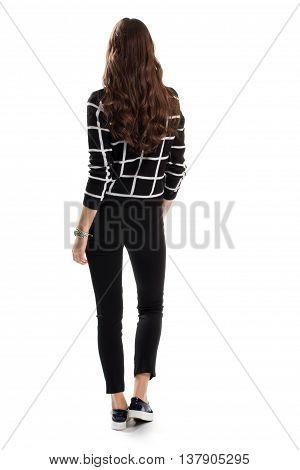 Woman in black checkered sweater. Back view of skinny pants. Trendy autumn look. Casual apparel from new catalog.