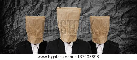 Group of businessman with brown paper bag on head on black crumpled texture