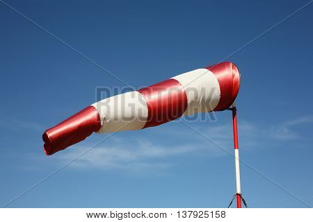 Windsock the cloudy sky background. Wind southwest.