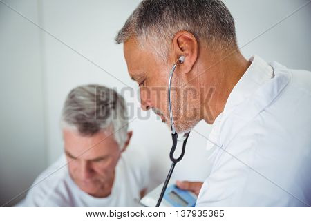Doctor using stethoscope in a retirement home
