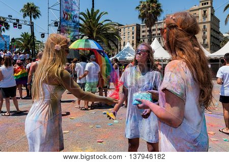 BARCELONA SPAIN - JULY 9 2014: Girls painted each other on Holi festival at Escenario del Moll de la Fusta.