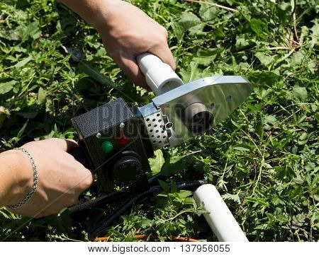 plumber with welding machine connecting plastic pipes.