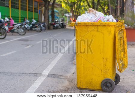 trash cans in the park beside the walk way.