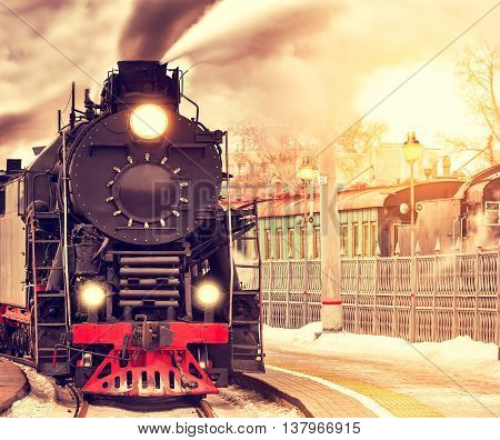 Arrival of the retro steam train at sunset time.