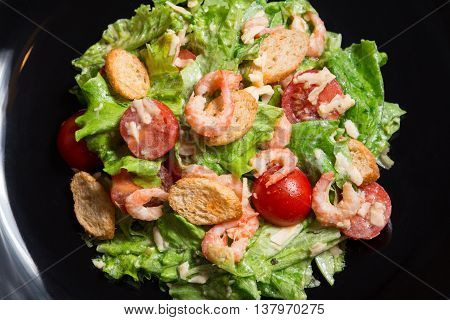 Caesar Salad with Shrimp on a black plate