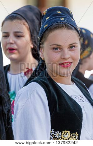 ROMANIA TIMISOARA - JULY 7 2016: Young woman from Romania in traditional costume present at the international folk festival "International Festival of hearts" organized by the City Hall Timisoara.