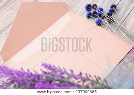 Light Envelope With Place For Text And Flowers On A Light Wooden Background