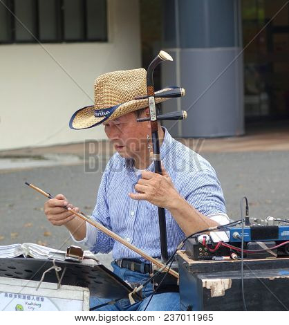 Kaohsiung, Taiwan -- February 16, 2018: A Street Musician Plays The Erhu, A Two-stringed Chinese Fid