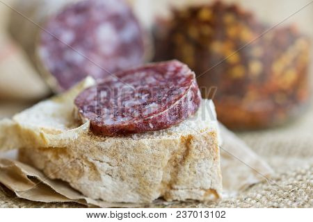 Slice Of Hot Salami With Crushed Hot Pepper On A Piece Of Bread