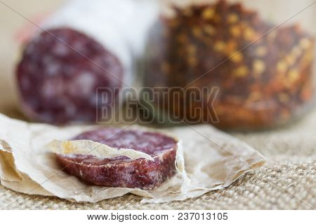 Slice Of Hot Salami With Crushed Hot Pepper On A Background