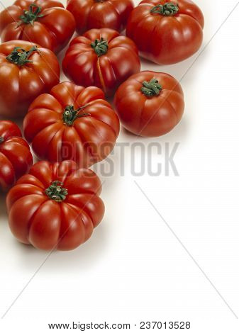 Photo Of A Table Top With Marmande Tomatoes Over A White Background.