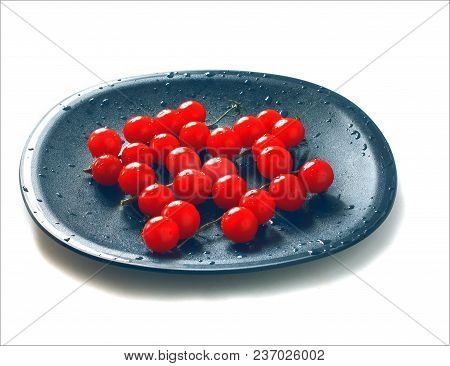 Red Cherry Tomatoes On Twigs With Water Drops On Black Plate