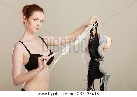 Bosom Concept. Slim Attractive Red Hair Woman Wearing Black Underwear Holding Many Bras In Hand, Cho