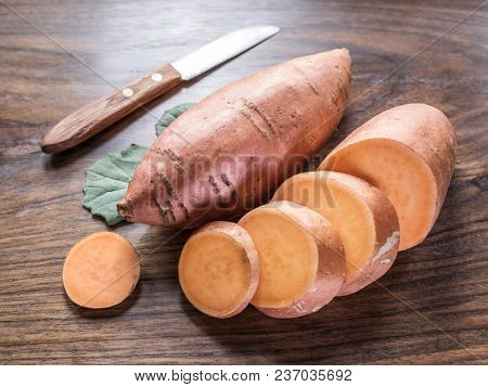 Sweet potatoes on the old wooden table.