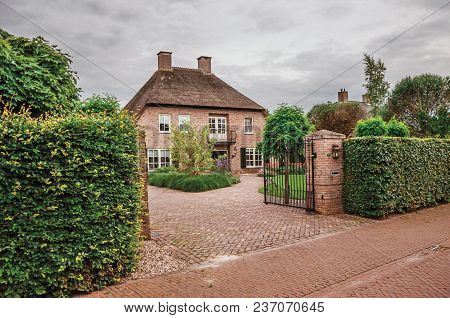 Drimmelen, Southern Netherlands - June 30, 2017. Entrance Gate Open To Courtyard Garden In Elegant B