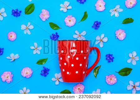 Ceramic Red Mug  With White Polka Dots On A Blue Background Amid The Buds Of White Cherry And Almond