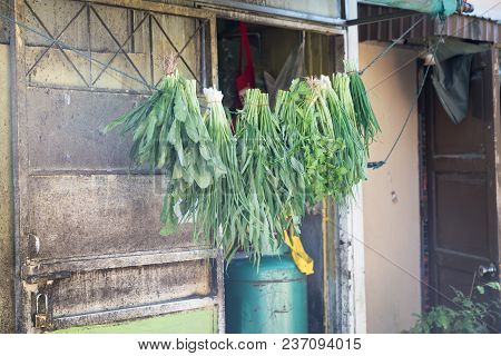 Vegetables Hanging Line Outside Back Door Of Asian City Restaurant In Narow Street.