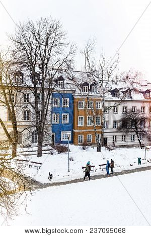 Colored Houses In Warsaw Old Town After Snow Storm In Winter, Colorful Exteriors Against The White S