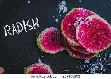 Watermelon Radishes Sliced, Sprinkled With Sea Salt On A Black Background