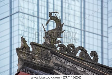 Dragon Sculpture On Daci Buddhist Temple Roof Against Modern Building In Chengdu, China