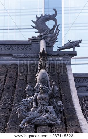 Dragon Sculpture On Daci Buddhist Temple Roof Against Modern Building In Chengdu, China