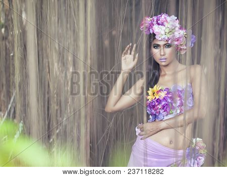 Young Asian Woman Tanned Skin And Black Shine Long Hair With Flowers Costume Design. Fancy Fairy Nym