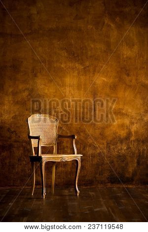Old Chair On A Brown Wall Background