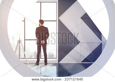 Businessman Looking Out Of Window In Abstract Interior With City View. Employment And Research Conce
