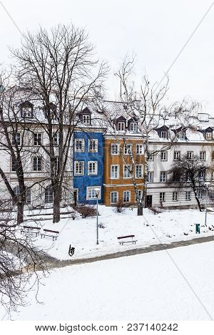 Colored Houses In Warsaw Old Town After Snow Storm In Winter, Colorful Exteriors Against The White S