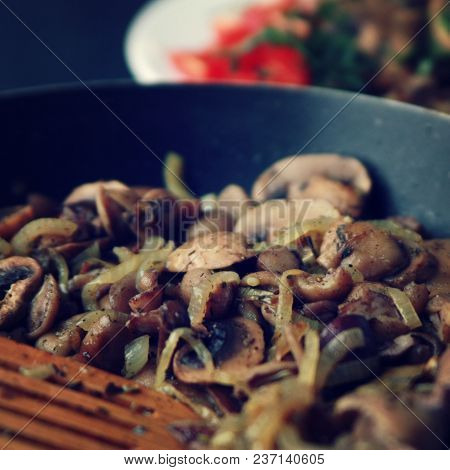 A Skillet With A Fried Mushrooms. Vegan Dish. Fried Mushrooms And Onion In The Frying Pan. European 
