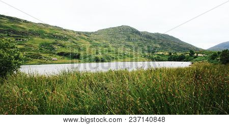 Lake And Green Hills. A Scenic View Of A Kerry Mountains And Surrounding Areas In County Kerry. Aged