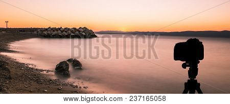 Camera On Tripod With Sunset Over The Sea In Background / Podgora, Croatia