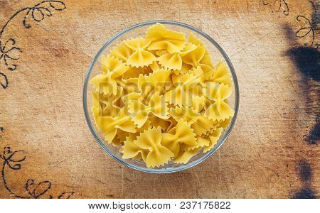 Farfalle Raw Farfallini Pasta In A Glass Bowl On A Wooden Cutting Board, Texture Background, In The 
